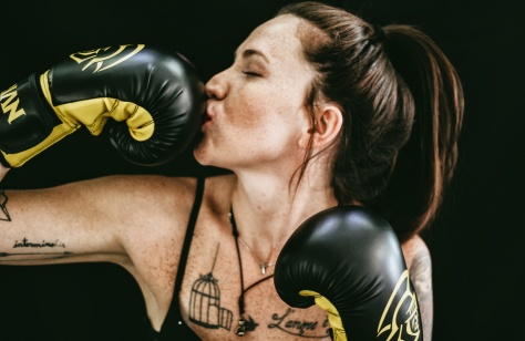 Boxerin küsst eine Hand im Boxhandschuh © Matheus Ferrero for Unsplash